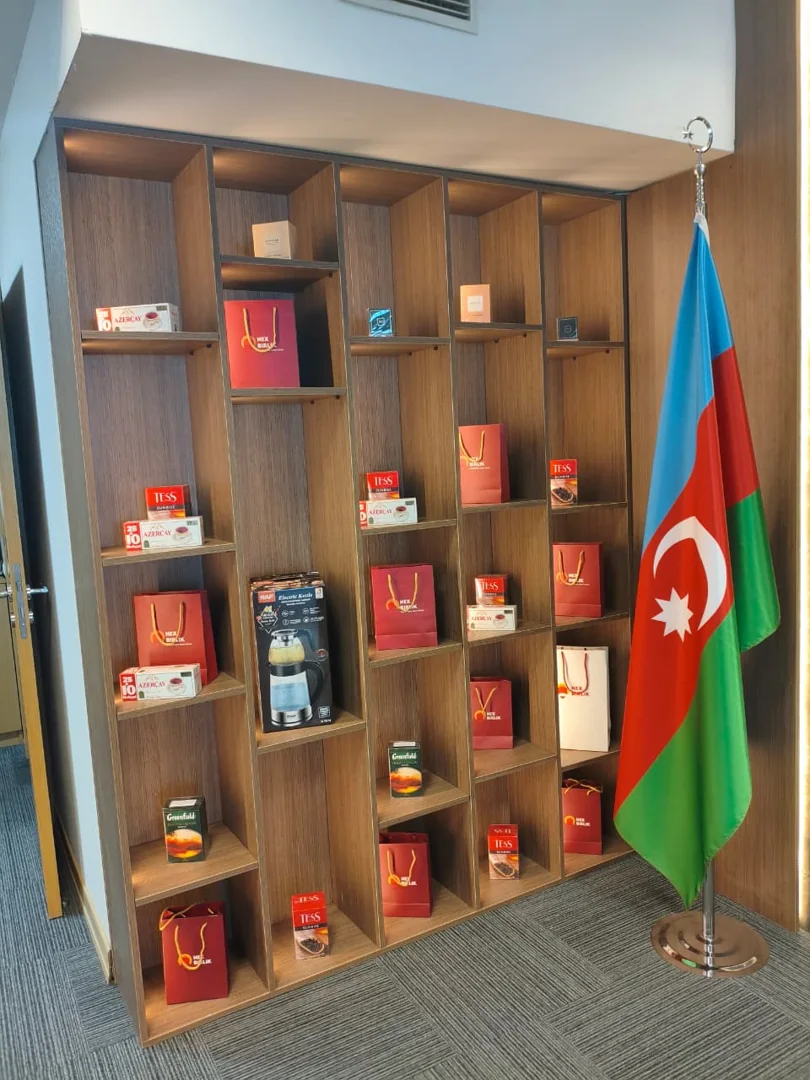 Bayrağın yanında ürünlerin sergilendiği raf